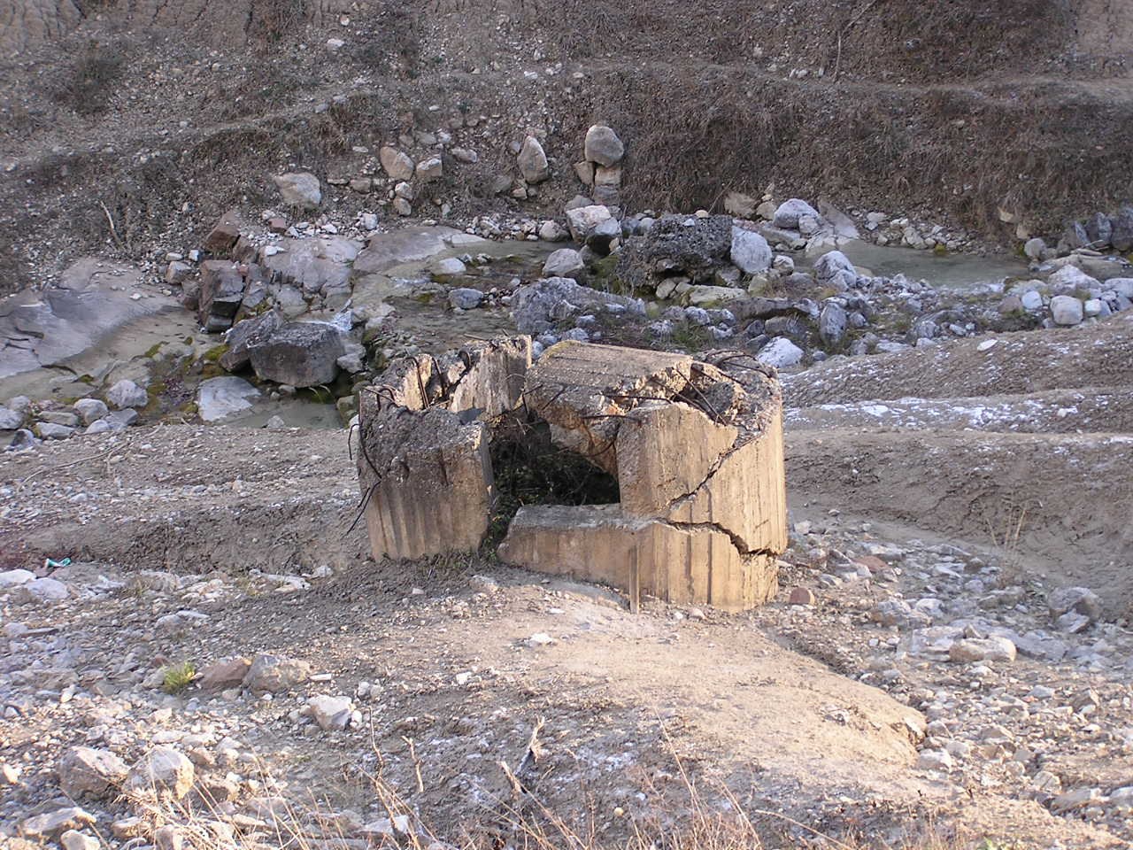 What is now left of an overflow tower swept away by the sudden release of fluid muds after failure. The towers' diameters - three to four metres - gives an idea of the total amount of waste material planned to be stored inside the basin rising upstream of Sgorigrad. 